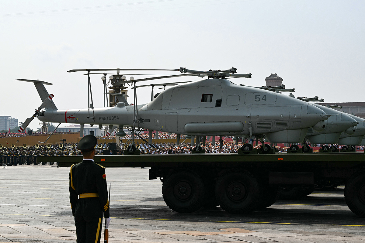 Photograph of multiple unmanned helicopters mounted on trucks during military parade