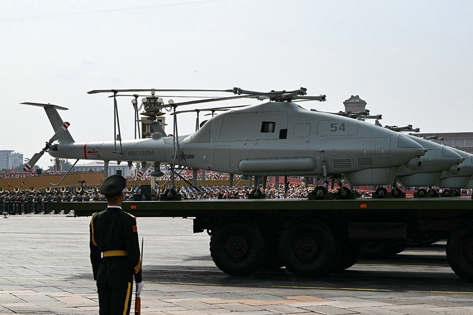 Photograph of multiple unmanned helicopters mounted on trucks during military parade