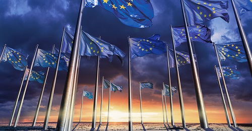 Image of EU flags against a sun rise representing defence spending outlook