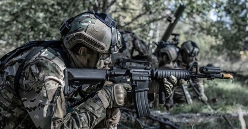 A Swedish soldier equipped with?Saab?Gamer simulation devices, including a laser detector device on the helmet, and a laser transmitter on the weapon barrel behind the blank firing attachment.