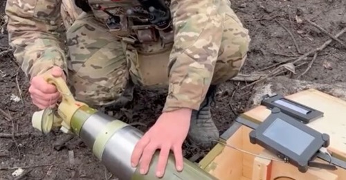 An image from a March 2026 Russian MoD video purporting to show a control panel with a touch screen being connected to the nose cone of a Krasnopol-M2 guided artillery round.