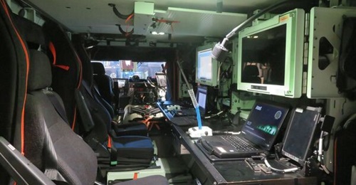 The interior of a Griffon vehicle command post variant with three SICS workstations.