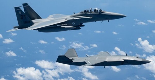 A Boeing F-15EX Eagle II of the USAF's 85th Test and Evaluation Squadron operates alongside a Boeing MQ-28A Ghost Bat during Exercise 'Valiant Shield 2026' over the Philippine Sea.