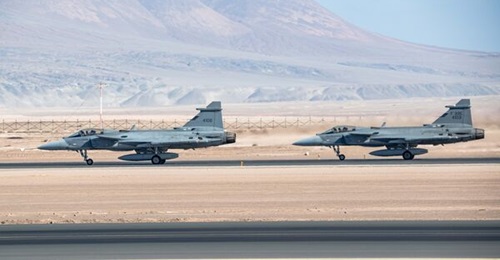 Two F-39E Gripen aircraft taxi on a runway in the Atacama Desert, Chile.