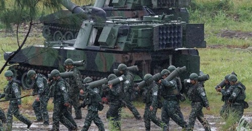 Taiwanese soldiers carry artillery shells for an M109A2 self-propelled howitzer during a live-fire training exercise in Taichung, central Taiwan, in June 2026.