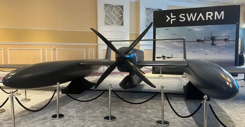 A full-size model of Swarm Aero's Gamera Group 5 UAS at the Air, Space, and Cyber Conference in September 2026. A JASSM/LRASM family cruise missile is shown carried on a central hardpoint.