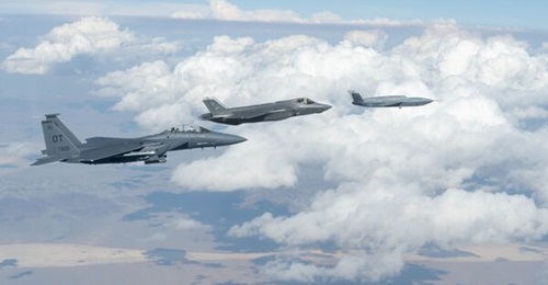 A GA-ASI GQ-42 flies alongside a McDonnell Douglas F-15E Strike Eagle and Lockheed Martin F-35 Lightning II.