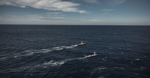 A computer-generated image of the transoceanic Oryx O-16 (above) and medium-range Oryx H-8 (below) unmanned surface vehicles co-ordinating through the Neptis distributed autonomy system during a surveillance mission at sea.