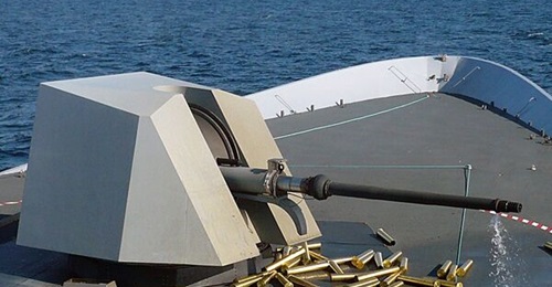 Leonardo 76 mm Super Rapid naval gun mount integrated on the bow of an unidentified warship, with spent munition shells scattered around the system.