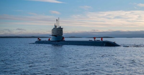 HMS Södermanland surfaced in coastal waters with small islands in the background which are characteristic of the Swedish archipelago. The image was taken from an FMV press release issued on 15 October 2026.