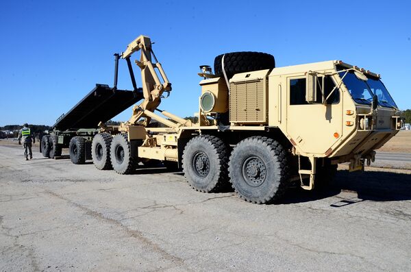 A HEMTT loads a flatrack on a PLS trailer. Kuwait has requested PLS trailers and flatracks but no HEMTT variants with the associated load-handling system. (Virginia National Guard)