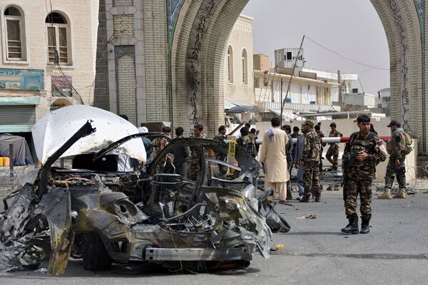 Afghan security forces personnel inspect the remains of a vehicle at the site of a bomb blast in Kandahar on 4 July. Although none of Afghanistan's 34 provincial capitals have fallen, the “strategic momentum” appears to currently be with the Taliban, said US JCS Chairman Gen Milley on 21 July. (Javed Tanveer/AFP via Getty Images)