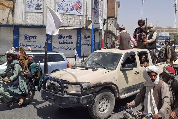 Taliban fighters drive an Afghan National Army vehicle through a street in Kandahar shortly after capturing the southern city on 13 August. (AFP via Getty Images)