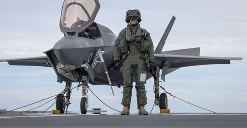 F-35B pilot, Squadron Leader Will, stands in front of his aircraft aboard 
        
        .