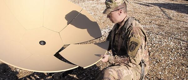 A US Army soldier assembles an expeditionary ground terminal for satcom operations. (US Army)