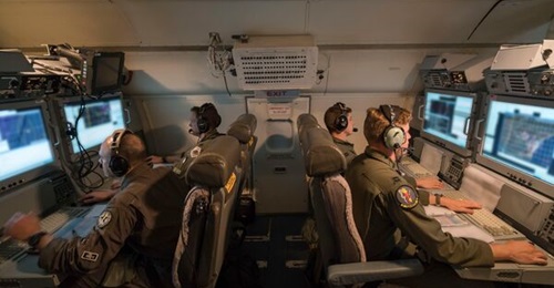 US Air Force aircrew members from the 116th Air Control Wing (ACW), Georgia Air National Guard, monitor surveillance data while flying a night mission aboard an E-8C JSTARS at Robins Air Force Base, Georgia, on 13 July 2017.