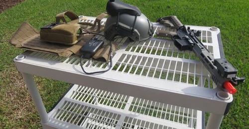 The components of Lockheed Martin's SIMRES geo-pairing system: player unit, helmet sensor, and weapon sensor mounted on the barrel of an Airsoft weapon that was being used for demonstration purposes.
