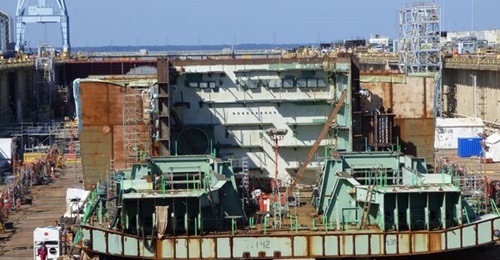 Aircraft carrier 
        
         is running 18-26 months behind schedule.