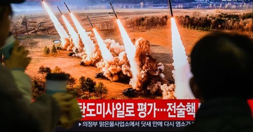 North Korea launched a salvo of 600 mm “super-large” multiple rocket launchers - towards the Sea of Japan (East Sea) - similar to its March 2024 launch pictured above on a TV at Seoul's Yongsan Railway Station.