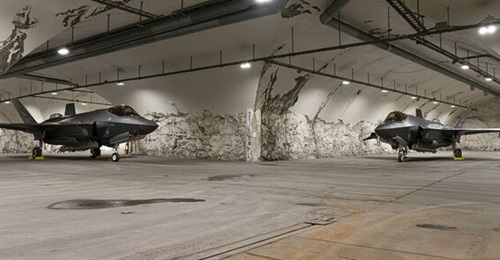 A pair of RoNAF F-35As sit parked in the mountain aircraft shelter at Bardufoss Air Station in the far north of Norway.