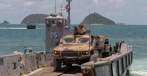 An Australian Army Hawkei PMV-L reverses onto a light landing craft from HMAS 
        
         at Cowley Beach in Queensland during Exercise 'Sea WADER 2020'. The DoD has announced that a braking issue with the vehicle has now been resolved.