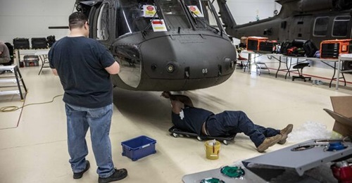 A Swedish Black Hawk helicopter being fitted for an auxiliary extended range fuel tank that can be carried inside the main cabin.