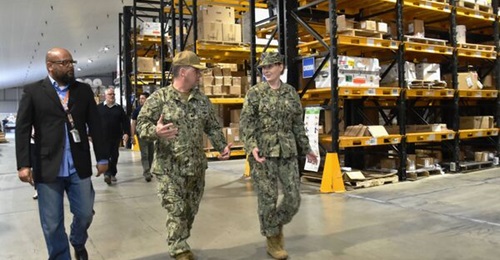 US Navy officials tour a Defense Logistics Agency warehouse at Naval Air Station Sigonella, Sicily, Italy. The DLA pre-positions equipment and goods at warehouses around the world.