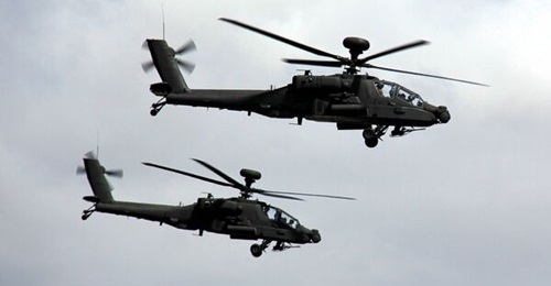 A pair of British Army AH-64E Apache helicopter gunships. The service intends to team the platform with an unmanned 'loyal wingman' from 2030.