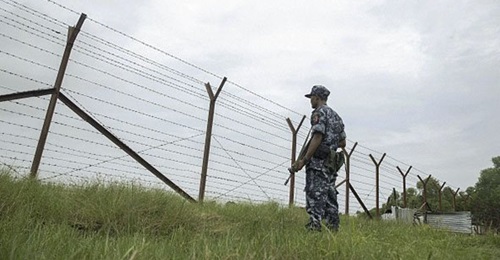 Myanmar border police patrol the fence in the 'no man's land' zone between Myanmar and Bangladesh in Rakhine state during a government-organised visit for journalists on 24 August 2018.