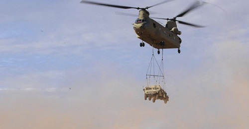 A CH-47 Chinook transports a Humvee during a sling load operation in July 2017. The US Army Reserve is set to acquire 60 JLTVs to train on in preparation for phasing out the Humvee.