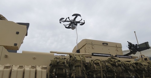The Nexter Robotics FINDEAGLE IXOS XX tethered UAS displayed above a Titus armoured vehicle at IDEX 2019.