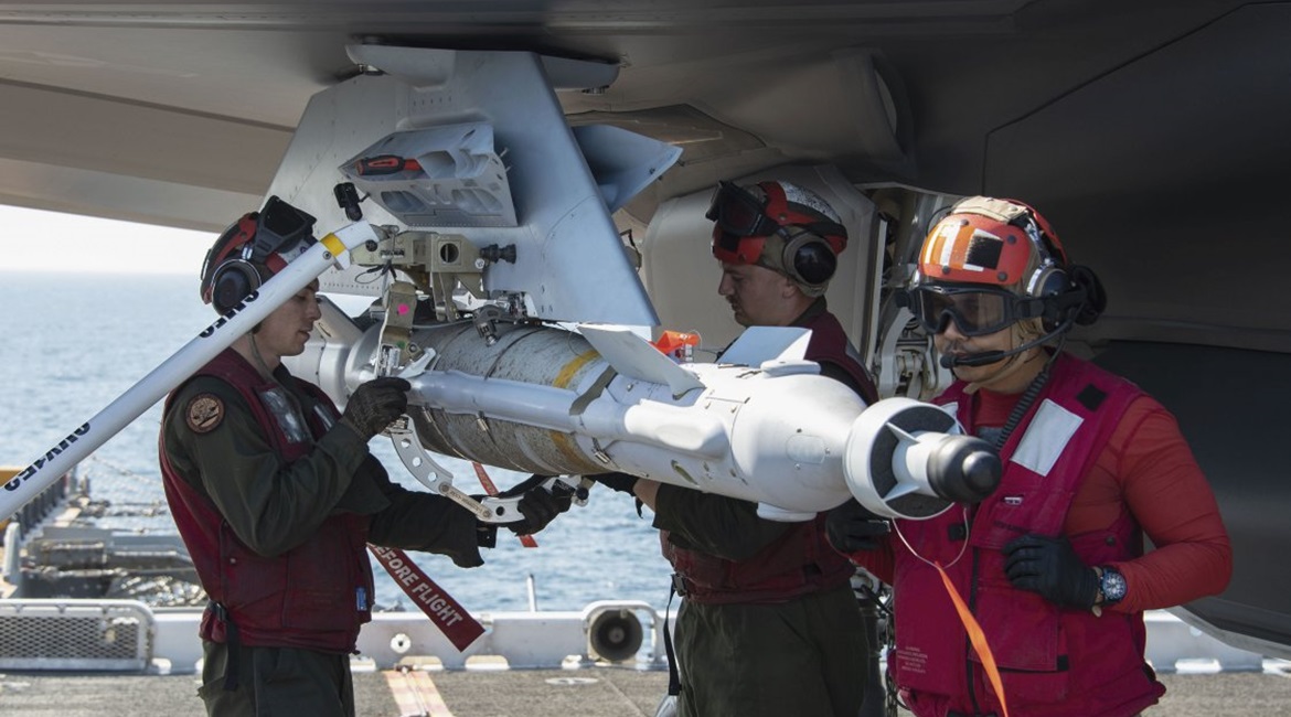 A GBU 49 is loaded onto an F-35B on the flight deck of Wasp-class amphibious assault ship USS 
        
         (LHD 2) on 12 December 2018. The USN modified an adapter, the white collar being removed by USMC Corporal Randle Lane (left), to l...