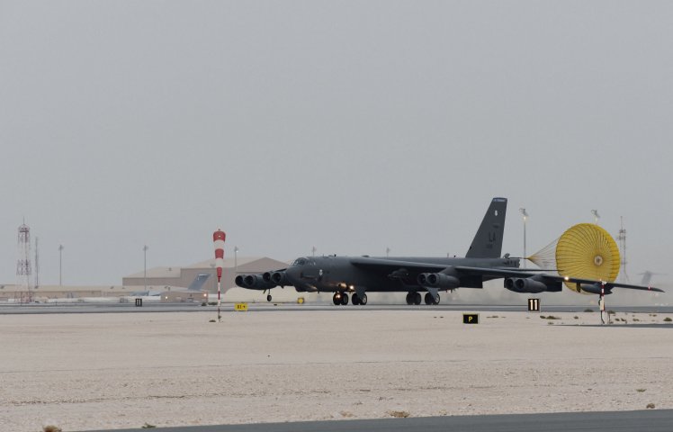 A US Air Force B-52H Stratofortress bomber taxis on a runway at an undisclosed base in the CENTCOM area of responsibility on 8 May. A Qatari C-17 transport aircraft and hangars identical to those at Qatar’s Al-Udeid Air Base can be seen in the background. (US Air Force)
