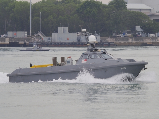 The mine detection variant of the Venus 16 unmanned surface vehicle leaving harbour for sea trials. The in-service Protector unmanned surface vehicle can be seen in the background. (IHS Markit/Kelvin Wong)