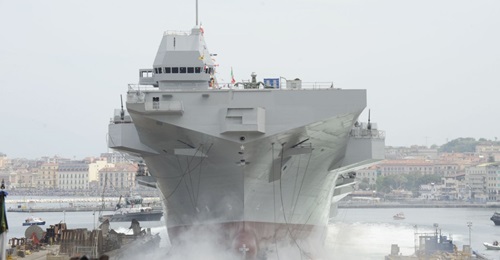 The LHD 
        
         during its launch. Note the limited space between the shipyard and Castellammare port's pier: just 450 m for a 214 m hull length, which required specific arrangements to increase hull friction in the water.