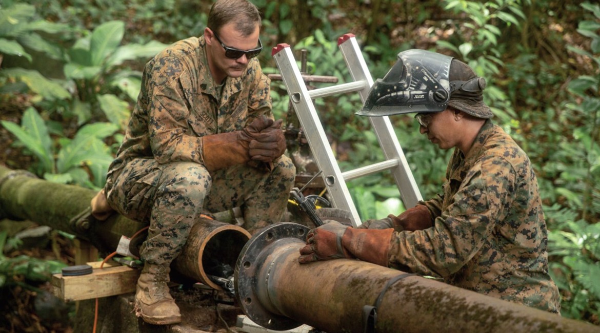 A US Marine with the SPMAGTF-SC assesses the repair process on a broken water valve in Trujillo, Honduras, during a 2018 deployment to Central America. Despite the Trump administration's pledge to cut off aid to El Salvador, Guatemala, and Honduras, th...