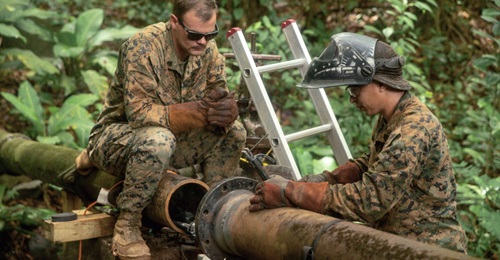A US Marine with the SPMAGTF-SC assesses the repair process on a broken water valve in Trujillo, Honduras, during a 2018 deployment to Central America. Despite the Trump administration's pledge to cut off aid to El Salvador, Guatemala, and Honduras, th...