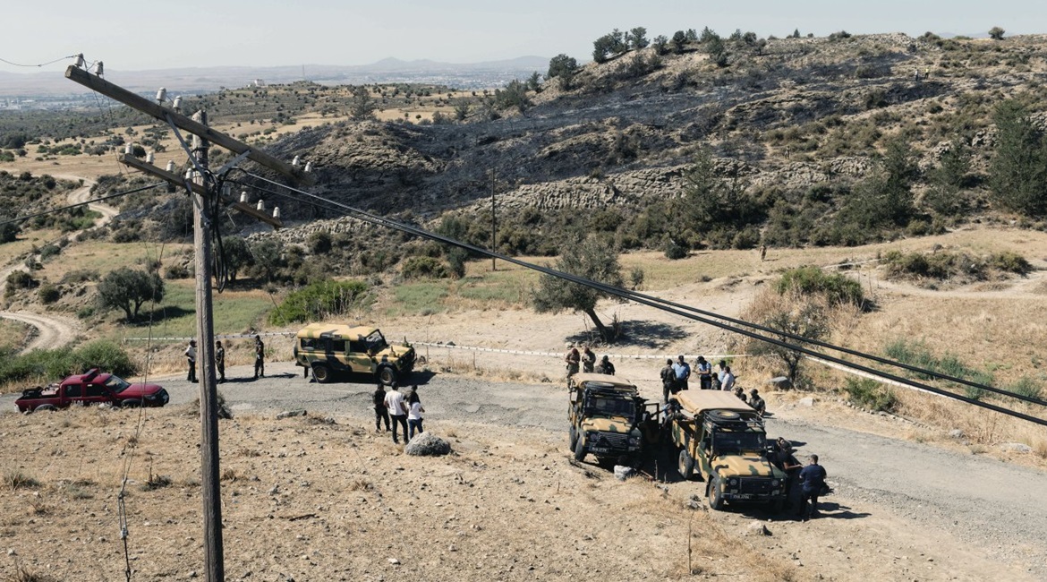 Members of the northern Cypriot security forces stand on a burnt portion of a slope where, according to officials, a suspected Russian-built missile exploded overnight on 1 July during an Israeli aerial raid in Syria.