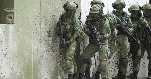 Singapore Army troops seen preparing to enter a mock building during urban warfare instruction. The service will have access to new high-tech urban operations training facilities from 2023.