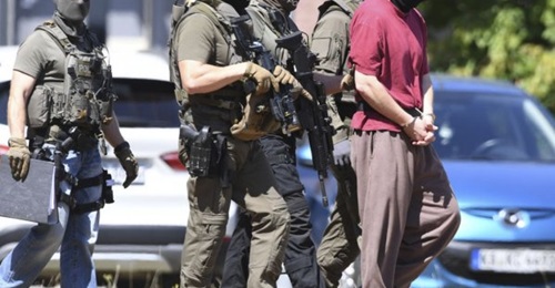 Police escort the main suspect in the killing of German politician Walter Lübcke back into custody following a hearing on 2 July.