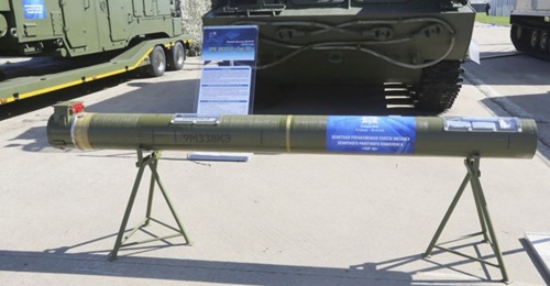 A 9M338KE surface-to-air guided missile displayed in its container in front of a Tor-E2 tracked combat vehicle at the MAKS 2019 International Air Show.
