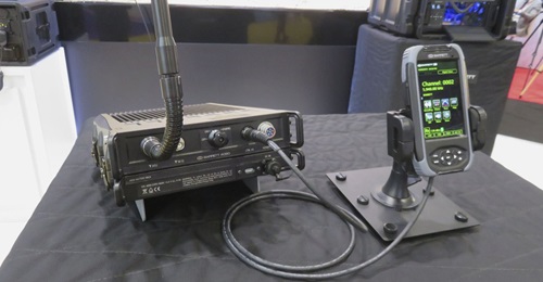 The Barrett PRC-4090 as shown at DSEI 2019 in the manpack configuration. The transceiver is mounted above the battery pack, with the control handset to the right.