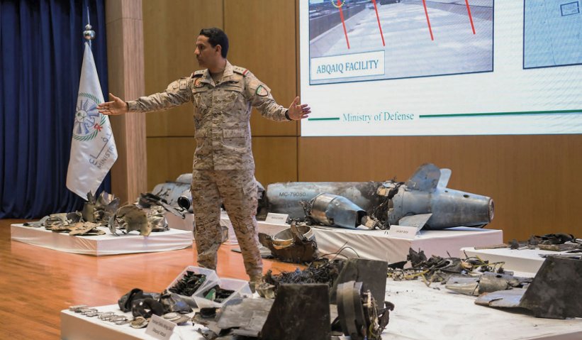 Saudi military spokesman Colonel Turki al-Maliki stands amongst the remnants of cruise missiles and UAVs recovered after the 14 September attacks on Saudi oil facilities. (Saudi Ministry of Defence)