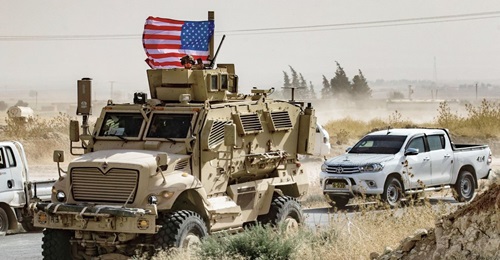 US troops patrol in the Syrian border town of Ras al-Ayn on 6 October, the day their withdrawal was announced by Donald Trump.