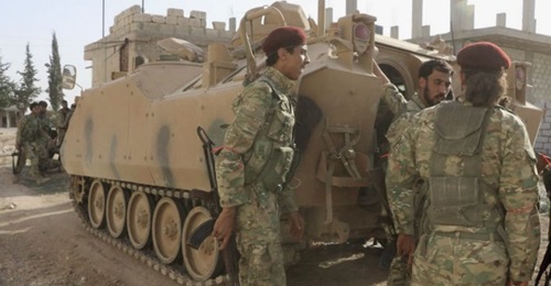 Turkish-backed Syrian fighters are seen with an ACV-15 APC in the Syrian border town of Tal Abyad on 10 October 2019.