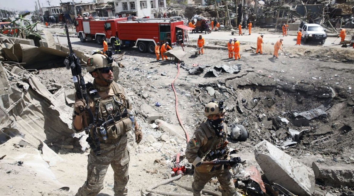 Afghan security forces near the crater left behind by a car bomb at the Green Village in Kabul on 3 September 2019.
