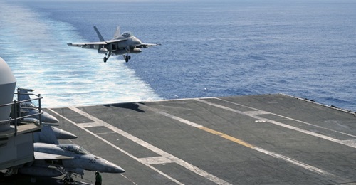 An F/A-18 approaching USS 
        
         for a full-stop landing after flight operations in the South China Sea.