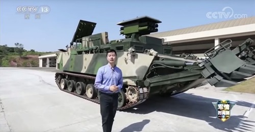 A still from a CCTV-13 video showing the PLANMC's new armoured breaching vehicle (background). The platform carries an array of systems designed to ensure that a force can move through obstacles as quickly as possible.