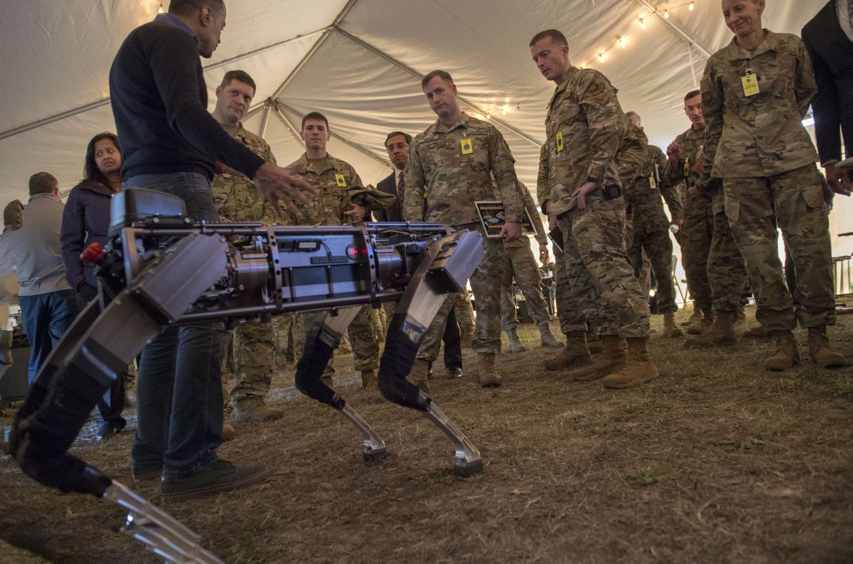Jiren Parikh (foreground), Ghost Robotics CEO, briefs USAF service members on 18 December 2019 on the capabilities of the ‘Robodogs’ during a technology showcase for the Advanced Battle Management System (ABMS) demonstration at Eglin Air Force Base in Florida. The ‘Robodogs’ are quadrupedal unmanned ground vehicles (Q-UGVs). (US Air Force)