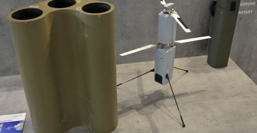 A Rafael Spike Firefly munition is pictured in the middle, with a three-munition launcher for vehicles on the left, and a transport canister for infantry on the right.
